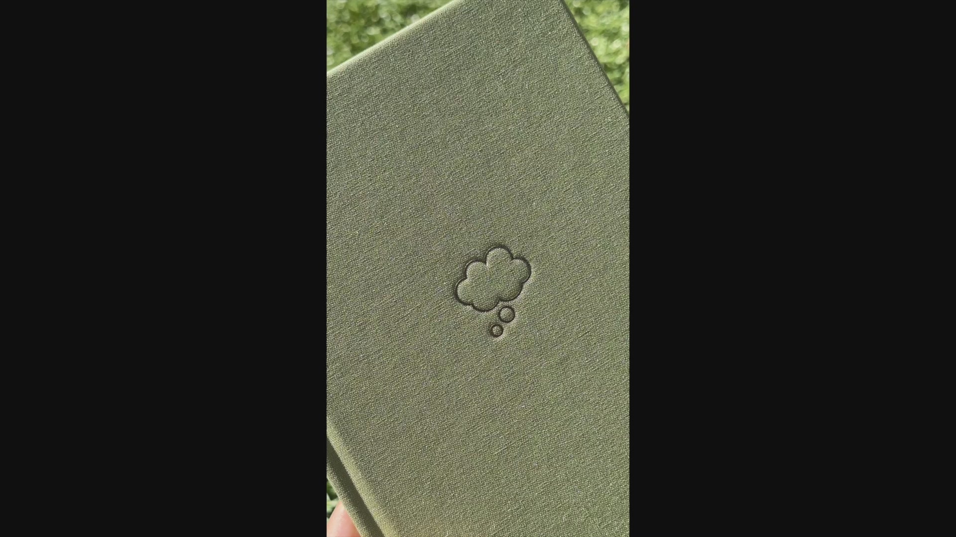 Video of shimmery light green Sprout Green Thought Journal with a champagne gold thought bubble illustration centered on the cover to show off the shine